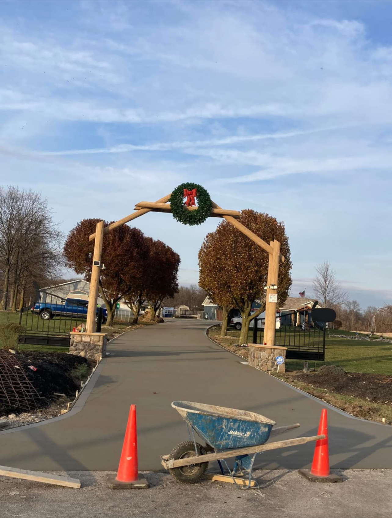 New concrete driveway entrance with wooden arch